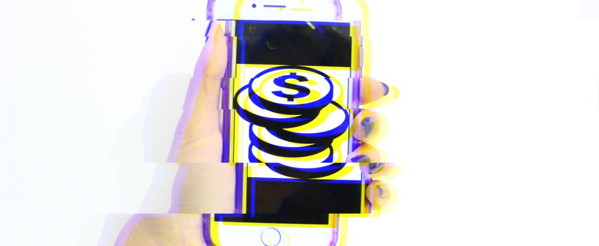 Uma mão segura um celular com uma foto com símbolo de moedas. A imagem foi distorcida para gerar um efeito futurístico.