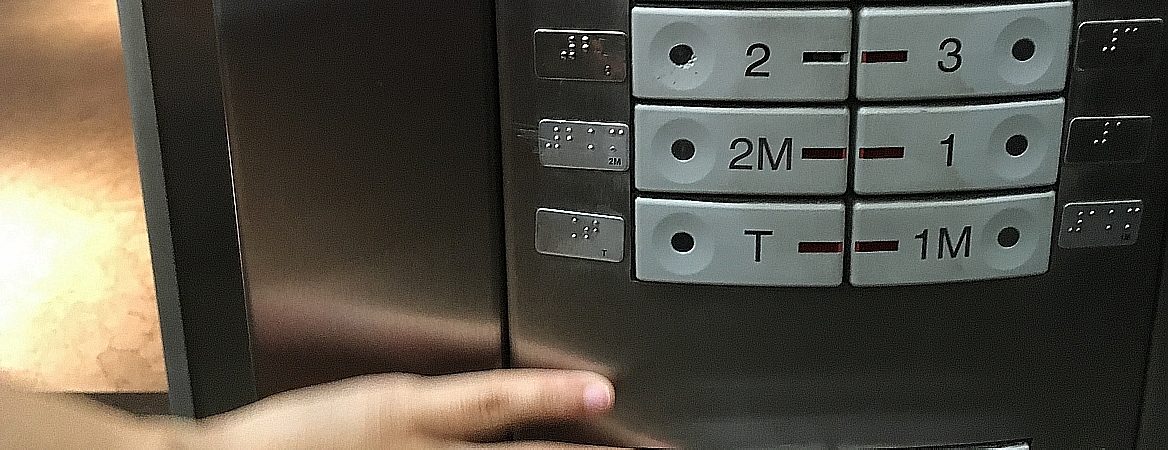 Mão segura elevador, com detalhe dos números dos andares aparecendo