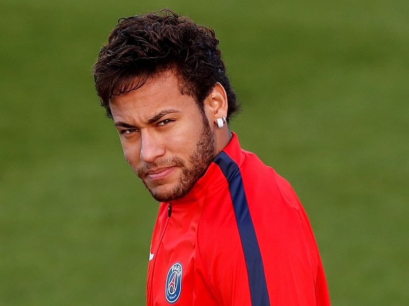 Jogador Neymar, com a camisa vermelha do Paris Saint Germain, faz olhar compenetrado durante treino do time na França